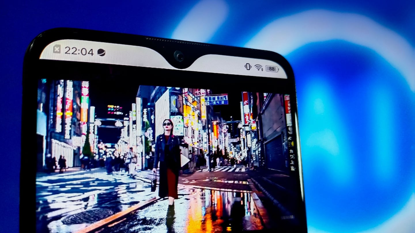 An AI-generated scene depicts a woman walking down a rain-slicked street bright with the reflected neon lights from buildings around.