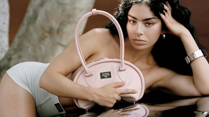 Charli xcx stars in new campaign for Acne Studios, holding one of the brand's handbags.